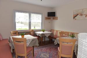 a restaurant with two tables and chairs and a window at Garni Hauenstein in Siusi