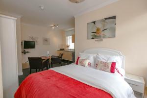 sypialnia z czerwono-białym łóżkiem i biurkiem w obiekcie Aparthotel Blackpool w Blackpool
