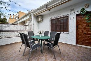 a green table and chairs on a patio at Espanhouse Diana bungalow in La Mata