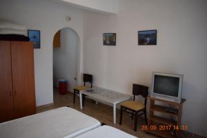 a room with a bed and a tv and a table at manolo studios corfu paleokastritsa in Paleokastritsa