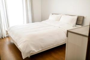 a white bed with white sheets and pillows at Kazaviti SKG in Thessaloniki