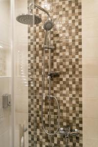 a shower with two lights on a tiled wall at Kazaviti SKG in Thessaloniki