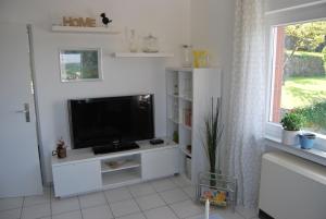 ein Wohnzimmer mit einem TV und einem weißen Entertainment-Center in der Unterkunft Talblick Gleiberg in Krofdorf-Gleiberg