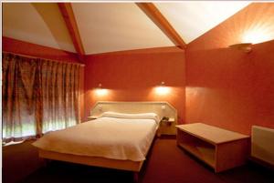 a red bedroom with a bed and a table at Logis Hotels - Hotel Restaurant l Enclos in Donneville