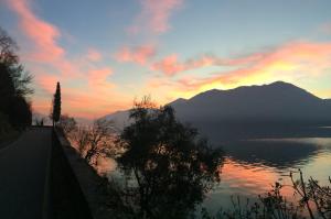 a sunset over a body of water with a mountain at Casa vacanze Dalia in Marone
