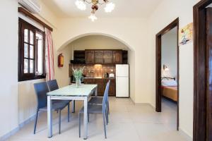 cocina y comedor con mesa y sillas en Dimitrios Apartments en Kassiopi