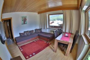 vistas panorámicas a una sala de estar con sofá y mesa en Ferienhof Riml, en Sölden