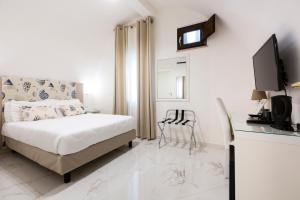 a white bedroom with a bed and a desk at Holiday Sorrento Center in Sorrento