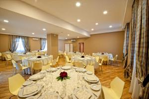 a banquet hall with white tables and white chairs at Hotel Villa Sturzo in Caltagirone