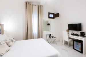 a white bedroom with a bed and a desk at Holiday Sorrento Center in Sorrento