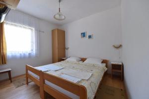 a bedroom with a bed in a room with a window at Apartmani Marko in Gdinj