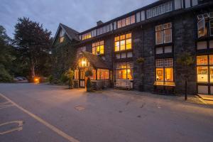 a large brick building with its lights on at Lake Vyrnwy Hotel & Spa in Llanwddyn