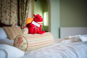 a red teddy bear sitting on top of a bed at Lake Vyrnwy Hotel & Spa in Llanwddyn