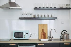 a kitchen counter with a microwave and a sink at Boutique Apartments Possonium in Bratislava