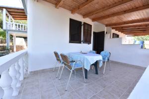 a dining room with a table and chairs on a patio at Apartmani Marko in Gdinj