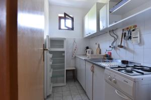 a white kitchen with a stove and a refrigerator at Apartmani Marko in Gdinj