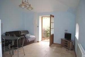 a living room with a couch and a table and a television at Domaine de la Poyat in Légny