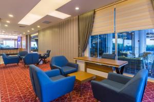 una sala d'attesa con sedie blu e tavolo e finestre di Lonicera Resort & Spa Hotel - Ultra All Inclusive ad Avsallar