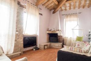 a living room with a couch and a television at Attico con Terrazza panoramica vista lago - LAKEHOLIDAY IT in Castel di Tora
