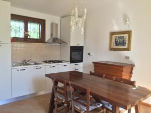 een keuken met een houten tafel en witte kasten bij Villa Poggio San Pietro in Mogliano