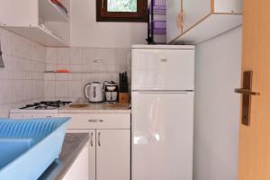 a white kitchen with a refrigerator and a stove at Apartmani Marko in Gdinj