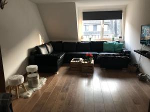 a living room with a black couch and a window at Winterbergappartments in Winterberg