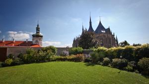 a garden with a green lawn in front of a building at Penzion a Restaurant Barbora in Kutná Hora