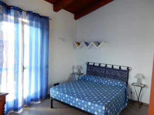 um quarto com uma cama azul com cortinas azuis em Residenza Albatros em Castiglione Falletto