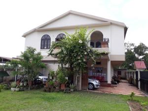 a white house with a car parked in front of it at Villa Shivalay in Dergaon