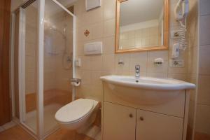 a bathroom with a toilet and a sink and a shower at Residence Araldina in San Cassiano