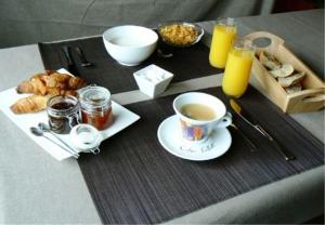 a breakfast table with a cup of coffee and pastries at Lou Lombrès in Lombrès