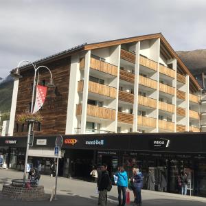 ツェルマットにあるApartment Center Zermattの目の前に人が立つ建物