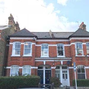 a red brick house with a white door at Wix's Lane in London