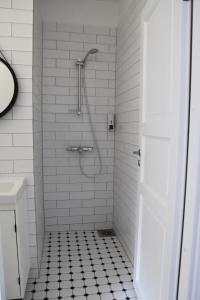 a bathroom with a shower with a black and white tile floor at Suur-Sepa apartement in Pärnu