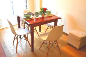 tavolo da pranzo con quattro sedie e un tavolo con fiori di Appartamento La Chicchera a Montespertoli