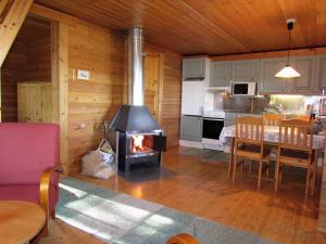 een keuken en eetkamer met een fornuis in een kamer bij Ukonloma Härkälampi in Rovaniemi