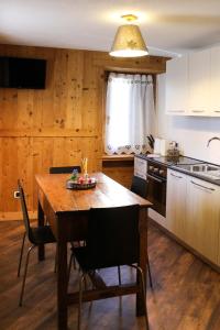 cocina con mesa de madera y sillas en Maison D'Antan Alloggio ad uso turistico VDA CHARVENSOD n 0022, en Aosta