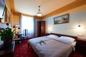 a hotel room with a bed and a vase of flowers at Hotel Stará Pekárna s privátním wellness in Liberec