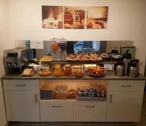 a counter with various pastries and food on it at Hotel Les Palmiers En Camargue in Saintes-Maries-de-la-Mer