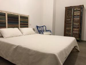 a bedroom with a large white bed and a blue chair at Zì Marì - Via Sirene in Polignano a Mare