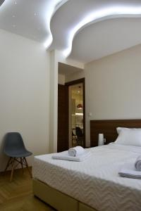 a bedroom with a large bed and a chair at Alke Homme in Athens
