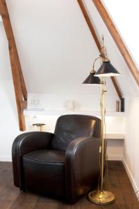 a black leather chair sitting next to a floor lamp at Boutique B&B Nassau in Amsterdam