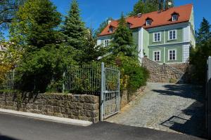 una cerca frente a una casa con una puerta en Hotel Stará Pekárna s privátním wellness en Liberec