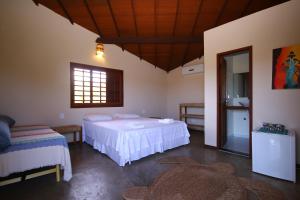 1 dormitorio con 2 camas y ventana en Pousada Vento do Kite, en Barra Grande