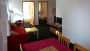 a living room with a red couch and a television at Apartmány Maruška in Stachy