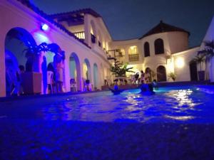 a house with a swimming pool at night at The Chill in Mansion Hostel Santa Marta in Santa Marta