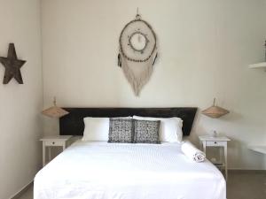 a large white bed with a clock on the wall at Harmony Glamping Boutique Hotel and Yoga in Tulum