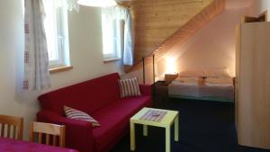 StachyにあるApartmány Maruškaのリビングルーム(赤いソファ、ベッド付)
