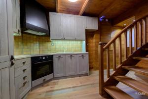 a kitchen with wooden cabinets and a staircase in a cabin at Kallisto Mountain House I in Arachova