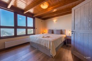 een slaapkamer met een bed in een kamer met ramen bij Kallisto Mountain House I in Arachova